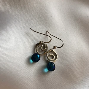 Handgjorda örhängen i glas och silver - Handgjorda örhängen i glas och silver (925). Total längd ca 2 cm. Aldrig använda.