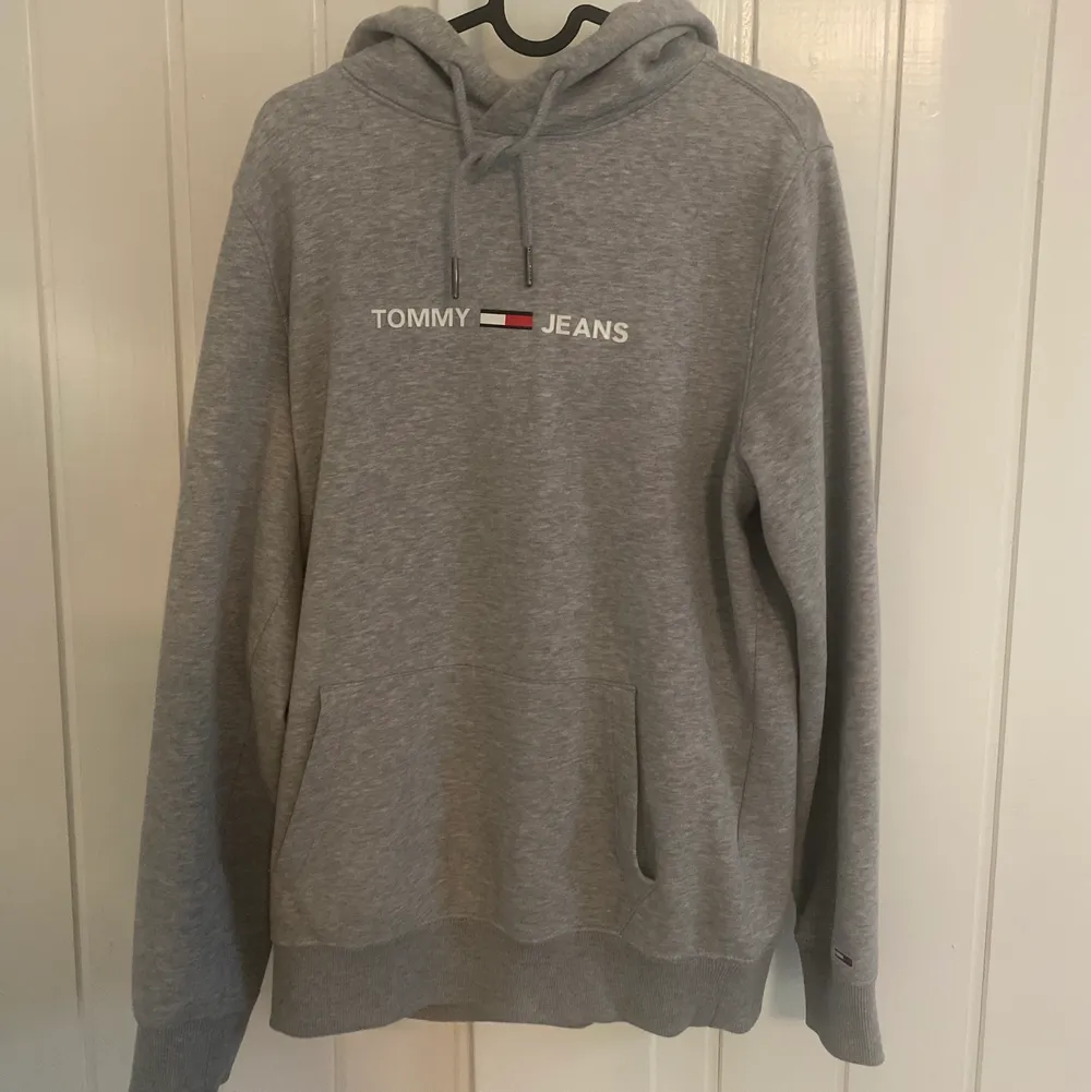 En grå tommy jeans hoodie använd ett fåtal gånger men är i ett superbra skick den är fläckfri och inget hål eller liknande, nypris 700kr. Tröjor & Koftor.