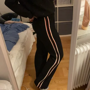 Svarta kostymbyxor &OtherStories - Svarta kostymbyxor från Other stories med röd-vit stripe på sidorna! Går att både klä upp och klä ner, storlek 34