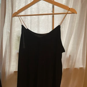 Svart linne med guldkedja  - Ett svart luftigt linne med guldkedjor som band, stolek 38. Kostnad 30kr+frakt 