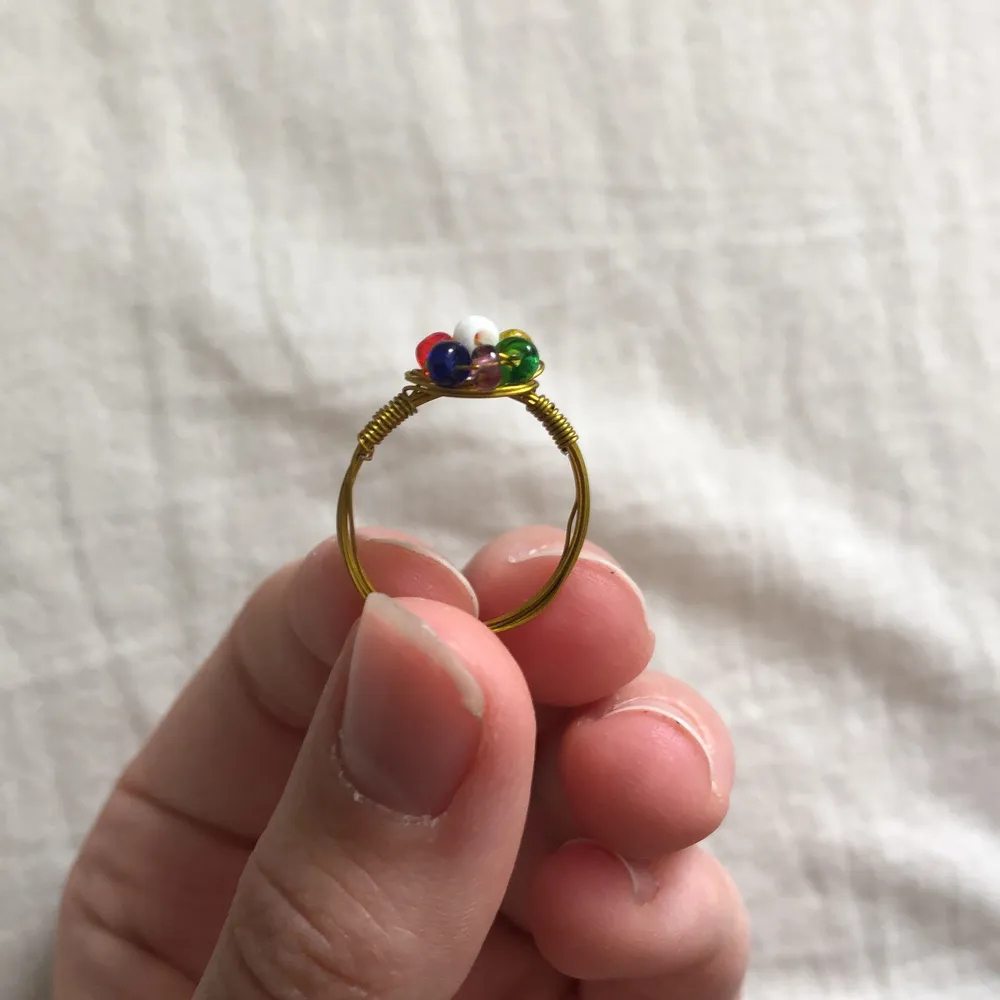 En handgjord ring med regnbågsfärgad blomma på. Väldigt fin och bra kvalite. Jag kan ändra färg på pärlorna, ändra storlek på ringen och ändra till roséguld eller silver istället för guld efter önskemål. Det är bara att kontakta mig. . Accessoarer.