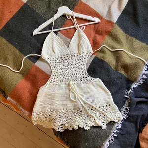 Vit virkad klänning - Virkad vit klänning med öppen rygg, köpt på sellpy men inte kommit till användning av mig, passar någon som inte är 180 (den va lite kort på mig) 🌞skriv om du har några frågor!