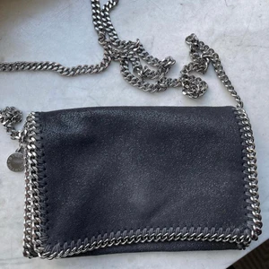 Väska Stella McCartney - Säljer min Falabella Shoulder Bag från Stella McCartney i svart med silvriga detaljer. Mycket gott skick, väldigt sparsamt använt. Köpt för ca 6000kr - 2800kr eller högsta bud 💕