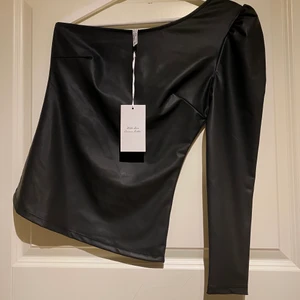 Skinntopp  - En one shoulder topp i fuskskinn, aldrig använd