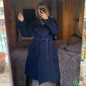 Whool coat in marine blue size medium. 100% whool, loose fit almost like size large. Pocket and belt. The coat is from danish vintage brand Elisabeth Rudolph and so the color of the coat is a bit faded. Missing one button. 