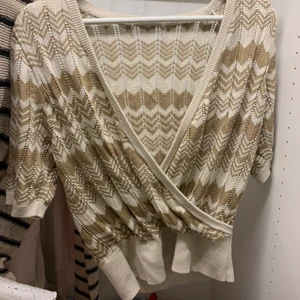 Tröja - Cool guldig omlotttröja med ett zickzack mönster, liknar missoni!! Tror att den är ifrån lindex men är inte säker! Lappen är tyvärr borta så vet inte vilken storlek det är men skulle tippa på M/L❤️‍🔥