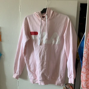 FILA - rosa fila-hoodie i storlek S, men generös i storleken. I väldigt bra skick och använd få gånger. Har en lite. Fläck mellan L och A, se bild 2. Går säkert att ta väck! Jättefin rosa färg som är ganska sällsynt❤️🌞