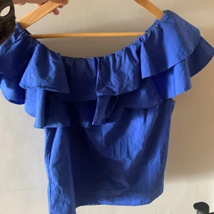 Blå topp! - Jättefin blå topp från nakd! Kan användas som både off shoulder och one sholuder! Perfekt till sommaren! Storlek 36 men passar både 34 och 38 enligt mig!
