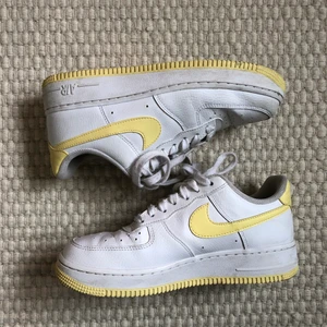 Air force 1  - Nike air force 1 med gula detaljer storlek 39. De har en fläck under sulan som endast syns litegrann på kanten när man står upp, men inget man direkt tänker på. I övrigt väldigt fint skick. Buda från 250 kr. Köparen står för frakt på 66 kr.🥰  budgivningen avslutas fre 23.00.  Högsta bud: 300 kr