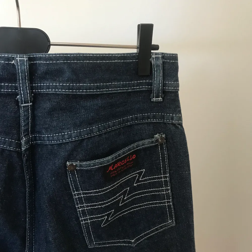 Otroligt coola mörkblå jeans från vintage-affären Pop Stockholm. De har vita kontrastsömmar och är långa i benen. Jag på bilden är ca 172 cm. Jeansen är rätt lågmidjade och vida, svagt utsvängda. Bra skick men använda. . Jeans & Byxor.