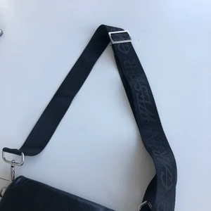 Väskband/axelrämsband - Säljer ett fint svart band till väskan från Carin Wester, väskbandet går att sätta på alla väskor (frakt tillkommer).      Kan sälja billigare vid snabb affär
