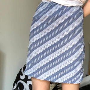 Blå kjol - En fin och somrig, blårandig kjol med knyte i midjan. 