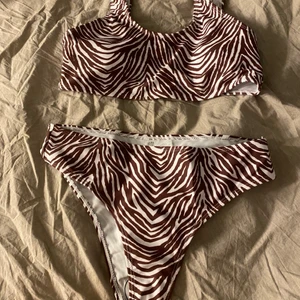 Oanvänd Brun Zebra Bikini  - En brun bikini med zebra mönster. Helt oanvänd! (Se bild nr.2) säljer pga av att jag råkade beställa två exakt likadana. Ordinariepris: 119kr    Strl: 160, skulle säga typ S på mig.         110kr+köparen står för frakt 🦓🤎