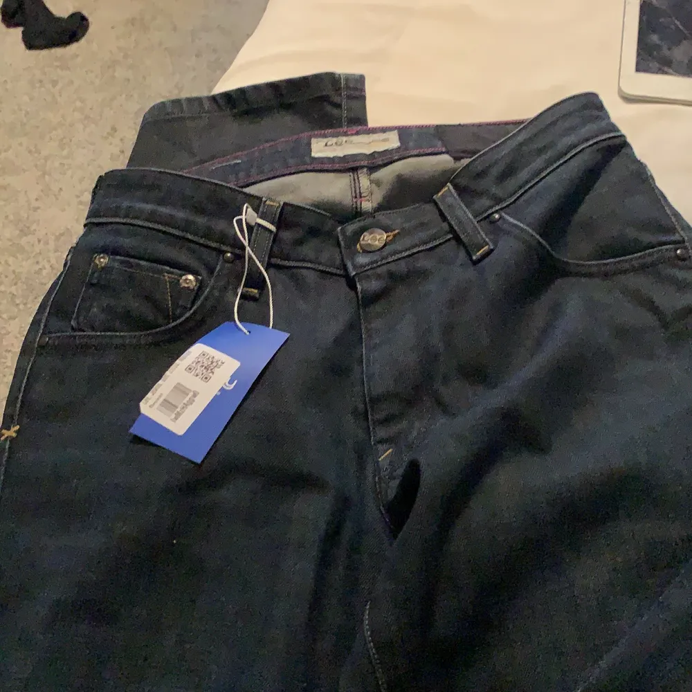 Supersnygga mörkblåa lowrise jeans från Lee. Helt nya och säljer pga att de tyvärr var för små. Bra skick. De passar som en strl 32/34.. Jeans & Byxor.