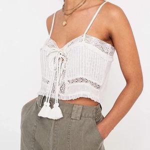 Urban Outfitters linne - Ett urgulligt, vitt linne från Urban Outfitters med fina detaljer. Det går att knyta om snörena hur man vill. 