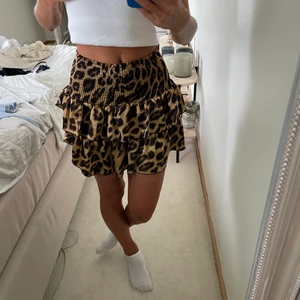 Kjol leopardmönstrad  - Kort kjol med leopardmönster,resår i midjan och volanger. Kjolen är köpt från Neo Noir. Storlek XS. Använd ett fåtal gånger. Köp direkt för 80kr eller buda i kommentarerna 💙💙💙