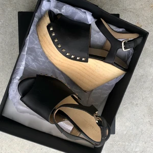 Svarta platå/platform sandaler, fr Zara - Svarta platå sandaler, från Zara.   Märke: Zara.  Storlek: 36 Högklackade skor platån är i träd , ca 11cm baktill och framtill 4-5cm. Med snygga nitar på sidorna.   Pris: 60 kr + frakt 66 ( spårbart)  Skick : Dem är sparsamt använda, På trädet är det lite mörkare på några ställen, men går säkert få bort med vatten eller suddgummi. Dem har även blivit svarta inuti framtill. Annars så fina. Se bilder.   🌸Har flera annonser uppe på kläder/saker så samfraktar.  🌸Övrigt rökfritt och djurfritt hem. 