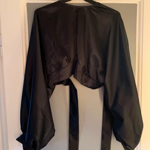 Festtopp i siden - Säljer denna skitsnygga festtopp då jag inte riktigt använder den! Den är öppen i ryggen, så man knyter snörena baktill för att få till pricken över i:t. Ballongärmar med fina knappdetaljer, skynda fynda ❤️❤️ strl M