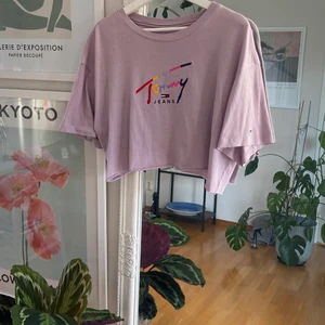 Crop-top (Tommy Hillfiger) - En kort Tommy Hillfiger tröja. Jag har klippt av den själv. Fint tryck på ryggen och fina färger. Tröjan är lila. Storlek L. True to size💕