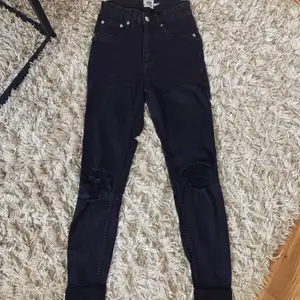 Svarta Snake jeans med slitningar på knäna. Stl. XS. Använt men okej skick. Från Lager157.