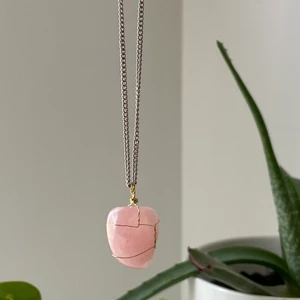 rosenkvarts halsband - äkta rosenkvarts kristall med metall tråd runt om och silver kedja. 