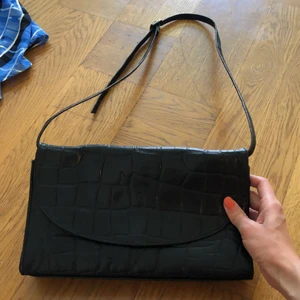 Secondhand väska - Vintage väska perfekt att bära på axeln. Reglerbara band och bra storlek på väskan för en utekväll, en innerficka, mobilficka (nycklar eller för läppstift 💄 ) samt en ytterficka med kedja! 💼  B: 28cM, H: 16cM, B: 6cM