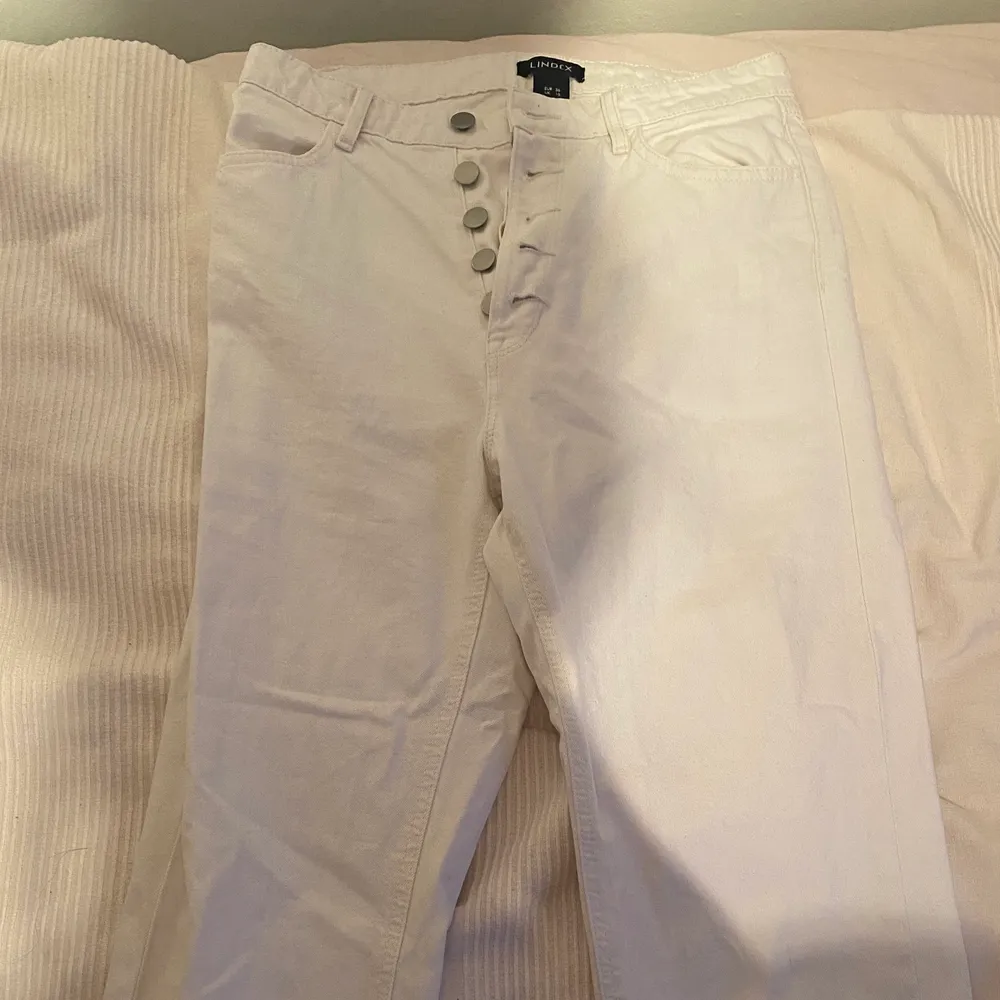 Vita jeans från Lindex, storlek 36. Väldigt söta, bra passform. Använda väl. Säljer för 45kr plus frakt.. Jeans & Byxor.