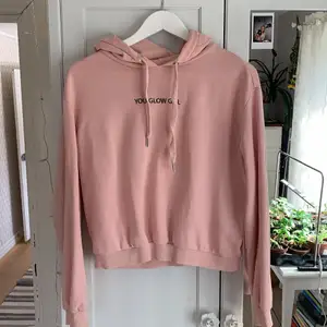 Rosa hoodie med texten ”You glow girl”.