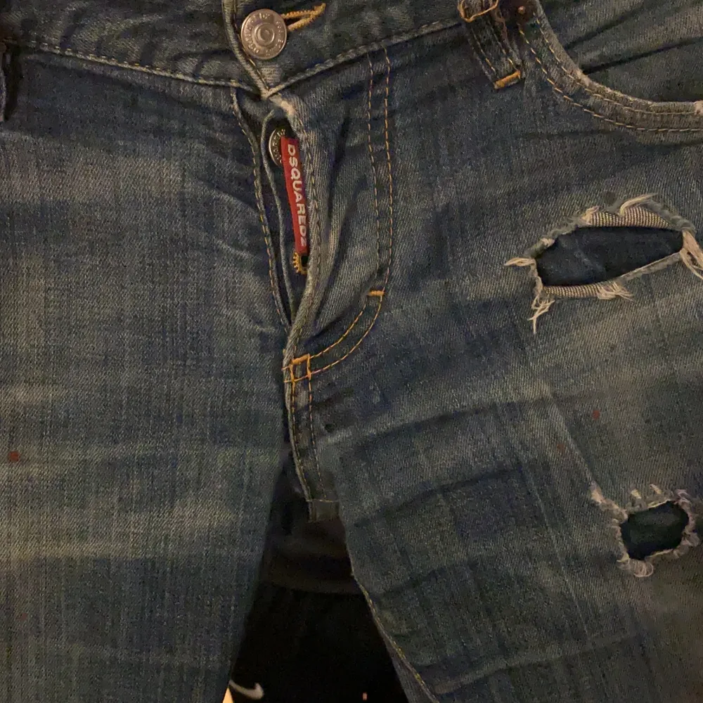 Mörkblå dsquared jeans med slitningar och färgstänk. Jeans & Byxor.