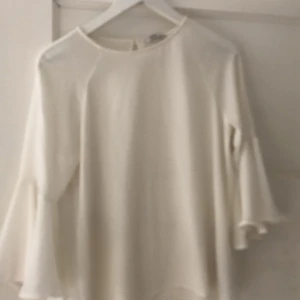 Vit topp - En fin somrig topp från Only. Den har utavängda armar och en liten öppning på ryggen. Använd flertal gånger men i bra skick. Köpare betalar frakt.
