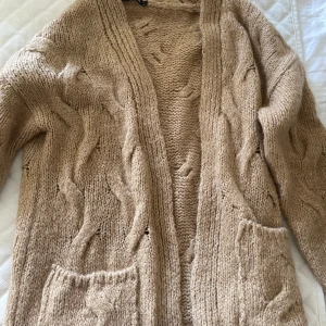 Virkad beige kofta  - Virkad beige kofta från trendyol. Knälång. Använd 1 gång