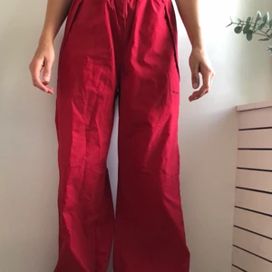 Röda pösbyxor - Ett par snygga pösbyxor i färgen röd som sitter puröst som man kan dra åt i midjan. Passar både till träning och vardag. Spänne nere vid anklarna och med stora fickor.