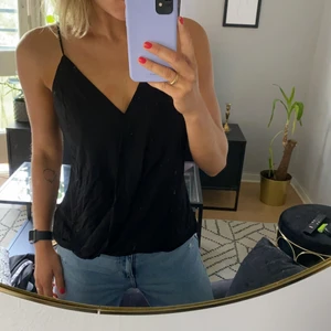 Svart omlottlinne från H&M - Svart omlottlinne från H&M. Banden går att spänna. Storlek 42.