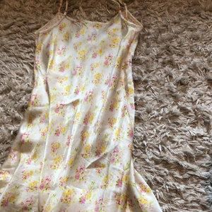 Vit blommig enkel klänning  - En vit blommig enkel klänning, Storlek xs ,Väldigt bra kvalitet,Säljer den då den inte riktigt är min still längre och den har nästan aldrig kommit till användning (köpare står för frakt)