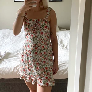 Blommig klänning - Blommig klänning i linnemodell. Miniklänning.