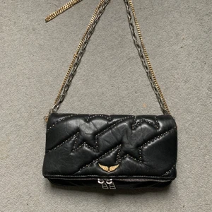 Zadig et Voltaire väska - Svart Zadig väska med både silver och gulddetaljer. Kvitto finns tyvärr inte då väskan var en present. Superfint skick och väl omhändertagen. OBS budgivning nu från 1300kr. 