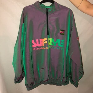 Holografic windbreaker  - En skitcool vindjacka av surfstyle, skimrande tyg och dragkedja vid halsen. Den är one size men funkar på både M L och XL. Frakt tillkommer på 50 kr. 