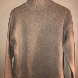 Beige stickad tröja med krage - En gosig ljust beige stickad tröja med krage. Inte alls stickig utan är i ett mjukt och varmt material. Otroligt skön och fin med liten kort slits på sidorna!