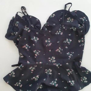 Linne omlottknäppning H&M - Sommarlinne med volang, omlottknäppning. Strlk 36  lappen bortklippt i nacken. Svart med mönster. Sparsamt använd.