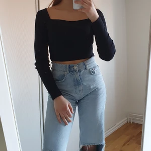Långärmad tröja - En ganska basic svart långärmad tröja med fyrkantig halsringning. Modellen är kort, nästan crop top.