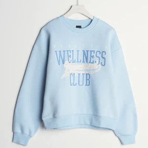 Ljusblå collegetröja med tryck på bröstet. Oversize fit - Tröjan är ända till rumpan på mig och jag är 160. Tröjan är i storlek S, egentligen tar jag storlek M på tröjor men eftersom att denna tröja är stor i storlek tog jag en storlek mindre. Den är köpt från Gina Tricot och jag har inte använt den. Anledningen till varför jag inte använt den är nog bara för att jag inte hade kläder som passa den.  