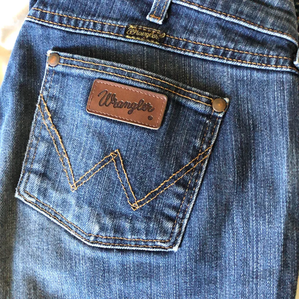 Wrangler bootcut jeans med cool slitning och låg midja. Står storlek 32x32 i dem men passar kanske någon som vanligtvis har S/M. Dom sitter bra på mig som har S bortsett från att dom är lite stora i midjan. . Jeans & Byxor.