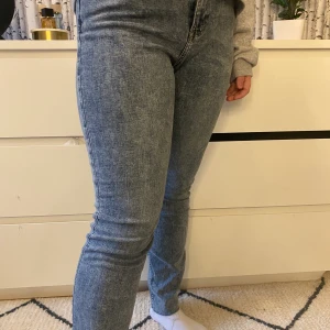 Jeans strl 42 - Snygga gråaktika jeans med normalhög midja och avklippta kanter längst ner, skinny jeans och stretchiga! Sparsamt använda
