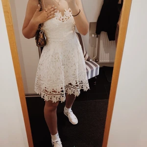 Vit klänning från Vila - Super snygg vit klänning från Vila. Ändats använd 1 gång, så är i nyskick! Perfekt för studenten eller skolavslutningen. Öppen rygg med band som korsas i ryggen. Man kan justera storlek och passform med banden på ryggen! Köparen står för frakt:)