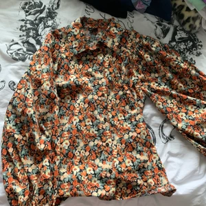 Blommig skjorta från Ginatricot - En skjorta med blommigt mönster från gina med stora puffiga armar. Den är i gott skick endast använts ett fåtal gånger (ej fri frakt)