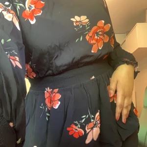 Blus med blommor  - Fin blus med röda blommor på, går in vid midjan och ger kroppen en fin form💗💗  bra skick!!