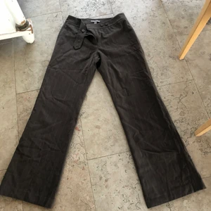 Kostymbyxor  - Randiga Brun-grå ish kostymbyxor som är mid-waist. Måtten är 78 i midjemått (midwaist), 76 innerben, och 26 i benutgånen! Passar också killar för en 70-tals look.