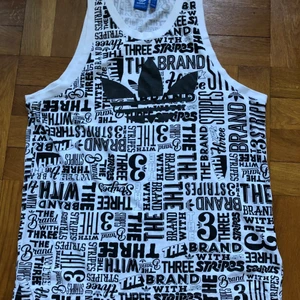 Adidaslinne strl L - Svartvitt linne från adidas i strl L (storlek L i mansstorlek).  Ett stort linne i Modell som ett basket linne/sport linne