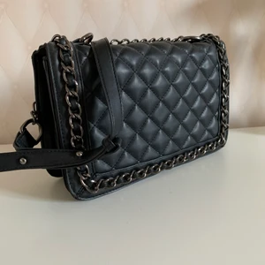 Rymlig handväska - Rymlig handväska med kedjedetaljer, justerbart band. Säljs för den inte kommer till användning. Inga synliga slitagetecken 🖤