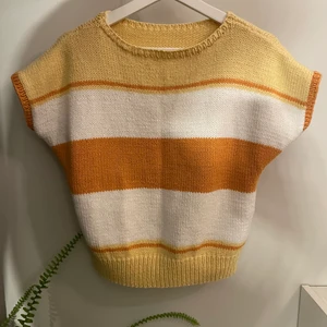 Stickad väst - En stickad väst med helt klockrena höstfärger! Den har nästan som små korta ärmar så blandning mellan väst och t-shirt. Okänd storlek men uppskattar till S